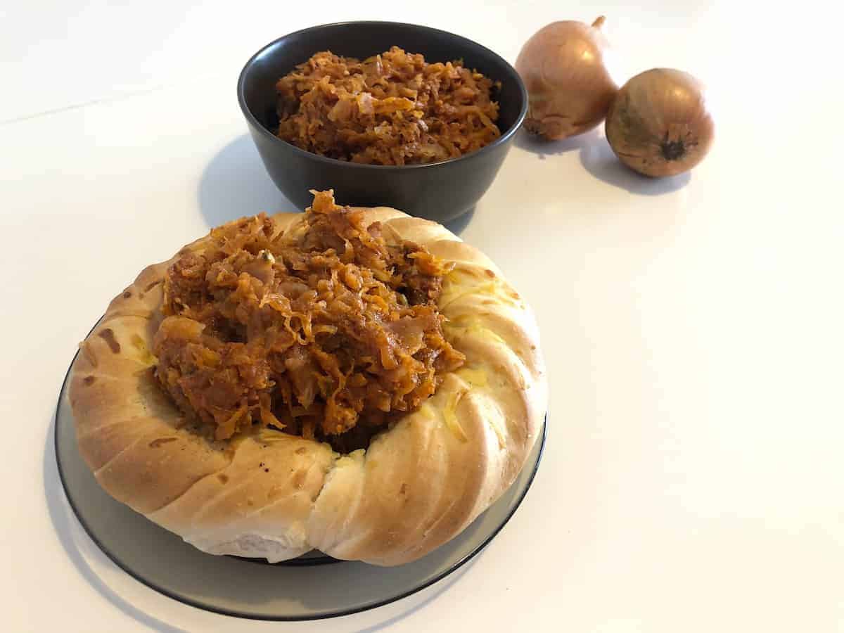 Bigos, the Polish Hunter's stew in a bread bowl and in a black bowl.