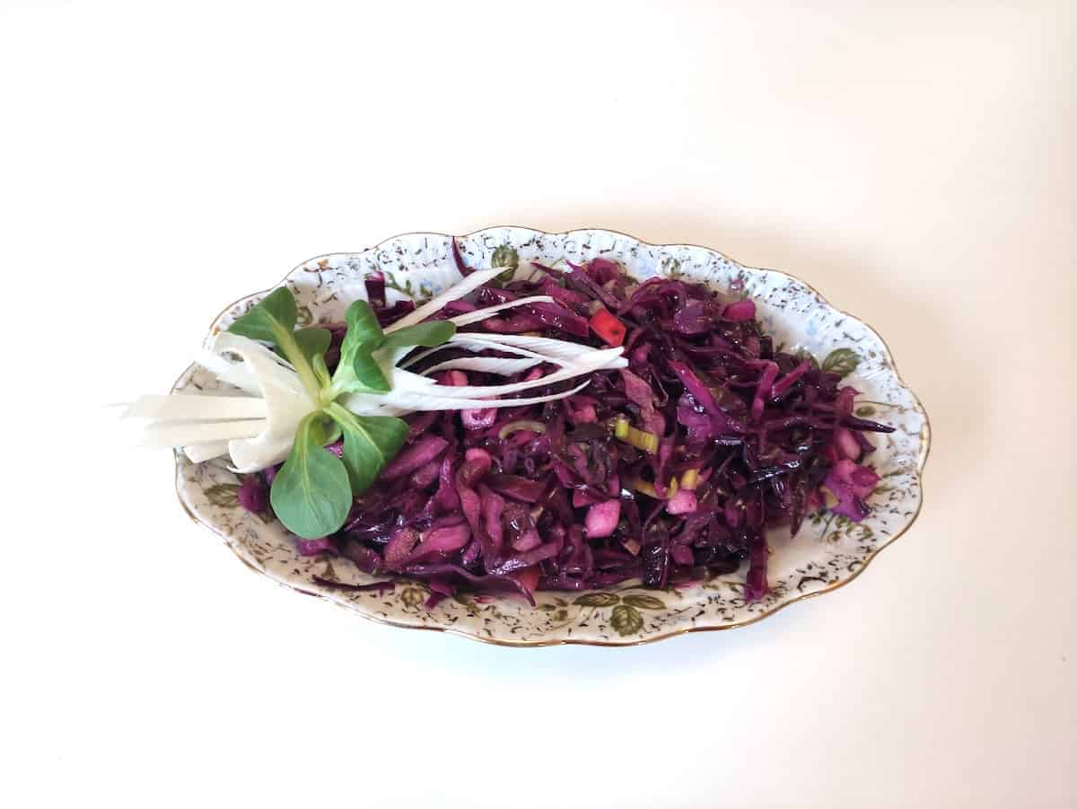 A Polish-inspired red cabbage salad recipe displayed on a white table.