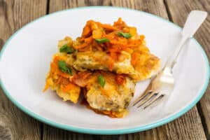 A plate with chicken and carrots on it.