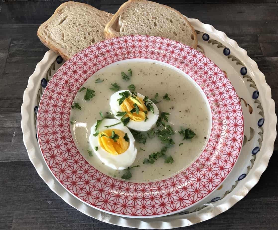Barszcz white soup in a red bowl.
