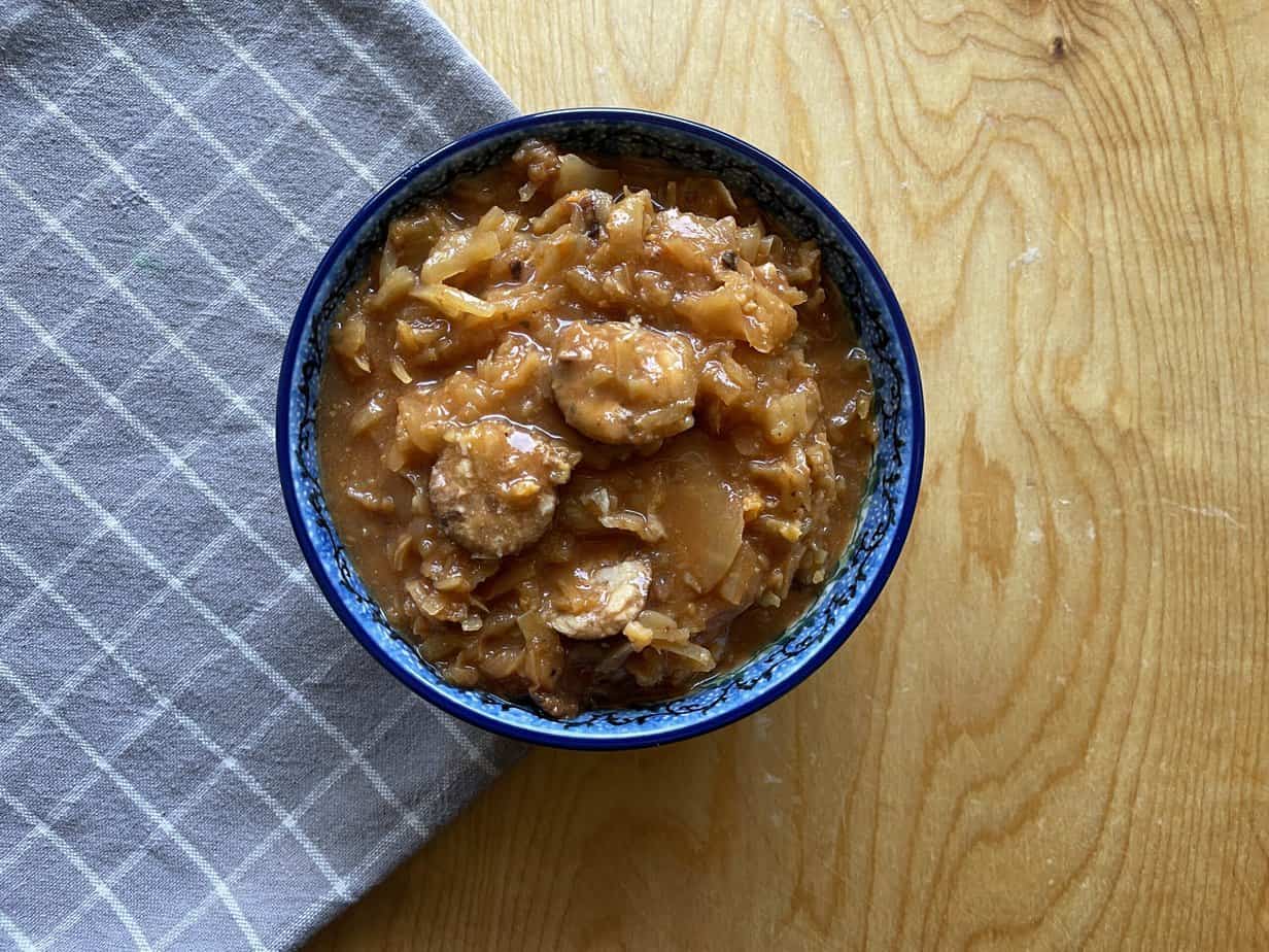 A bowl of authentic bigos on a wooden table.