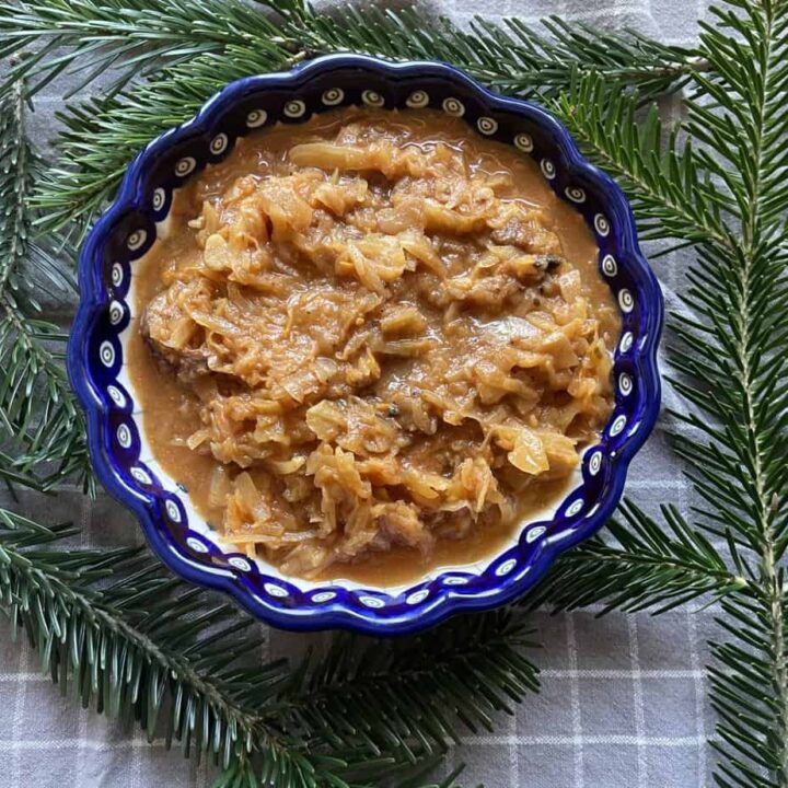 A bowl of authentic Polish bigos with a pine branch on it.