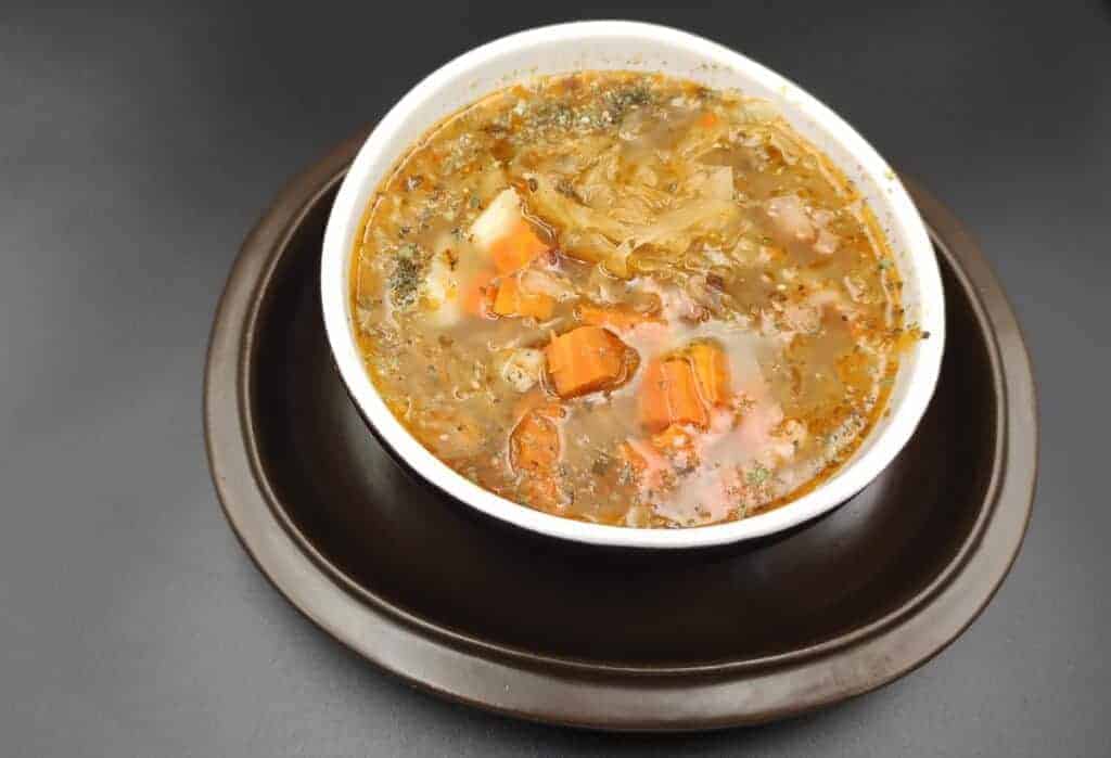 Kapusniak soup in a white bowl.