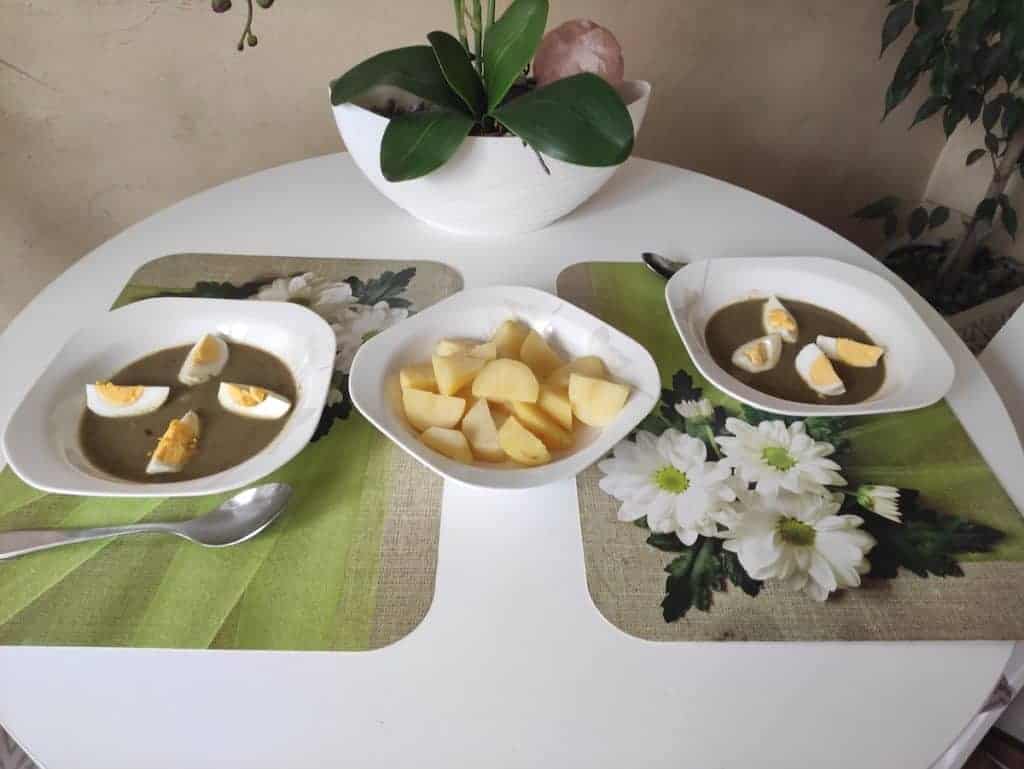 szczawiowa soup in two bowls with boiled potatoes in another.