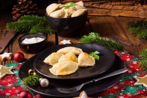 Mushroom and sauerkraut pierogi on a black plate.