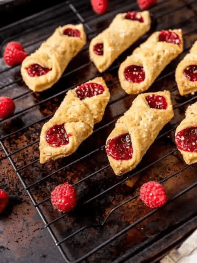 Freshly baked raspberry Kolacky pastries cooling on a wire rack.