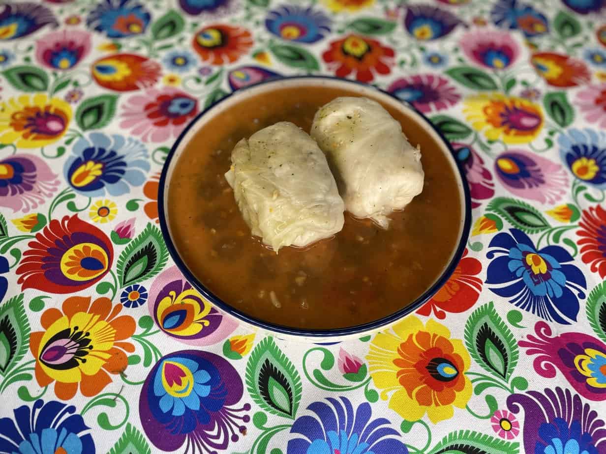 An authentic Polish golumpki recipe served with dumplings on a colorful tablecloth.