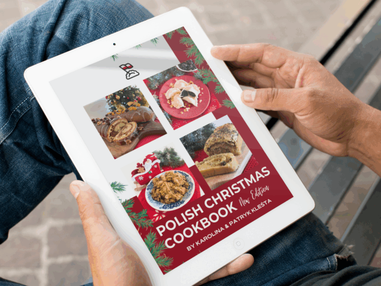 Person holding a tablet displaying the cover of a "Polish Christmas Cookbook," complete with festive decorations and photos of traditional dishes—an inspiring digital Christmas Kit for your holiday meals.